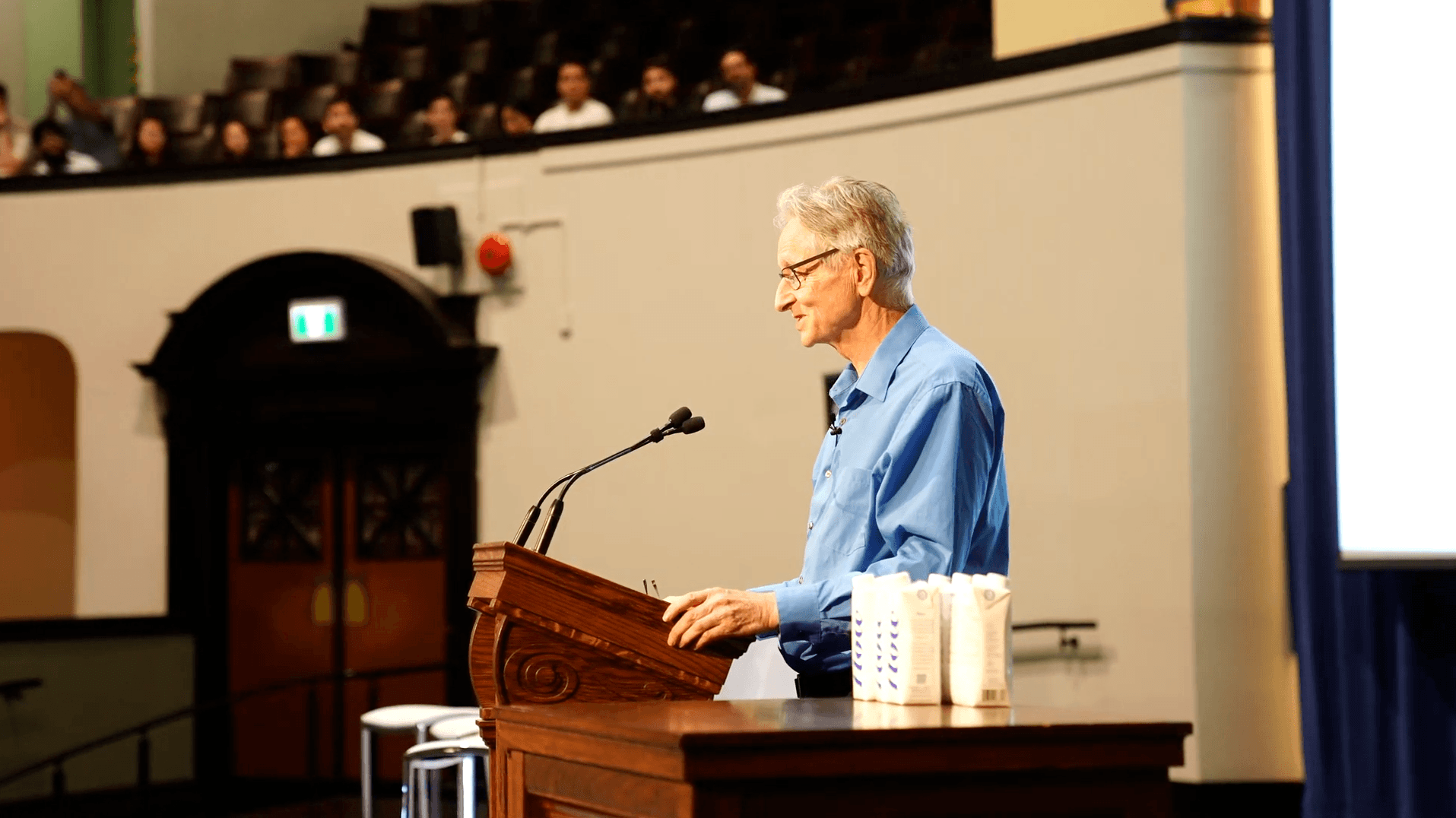 Geoffrey Hinton standing at a lectern
