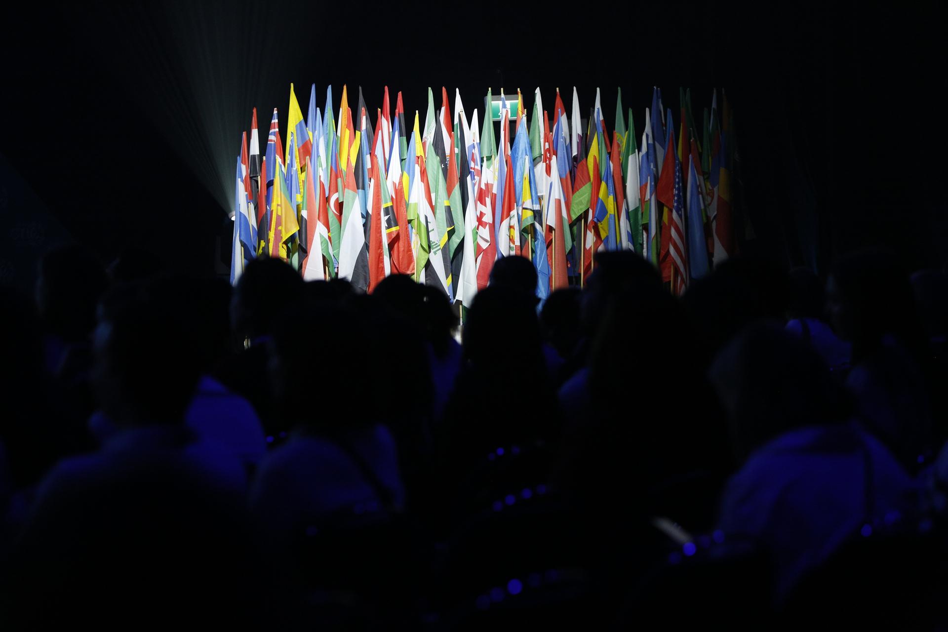 A large group of country flags lit up on a stage.