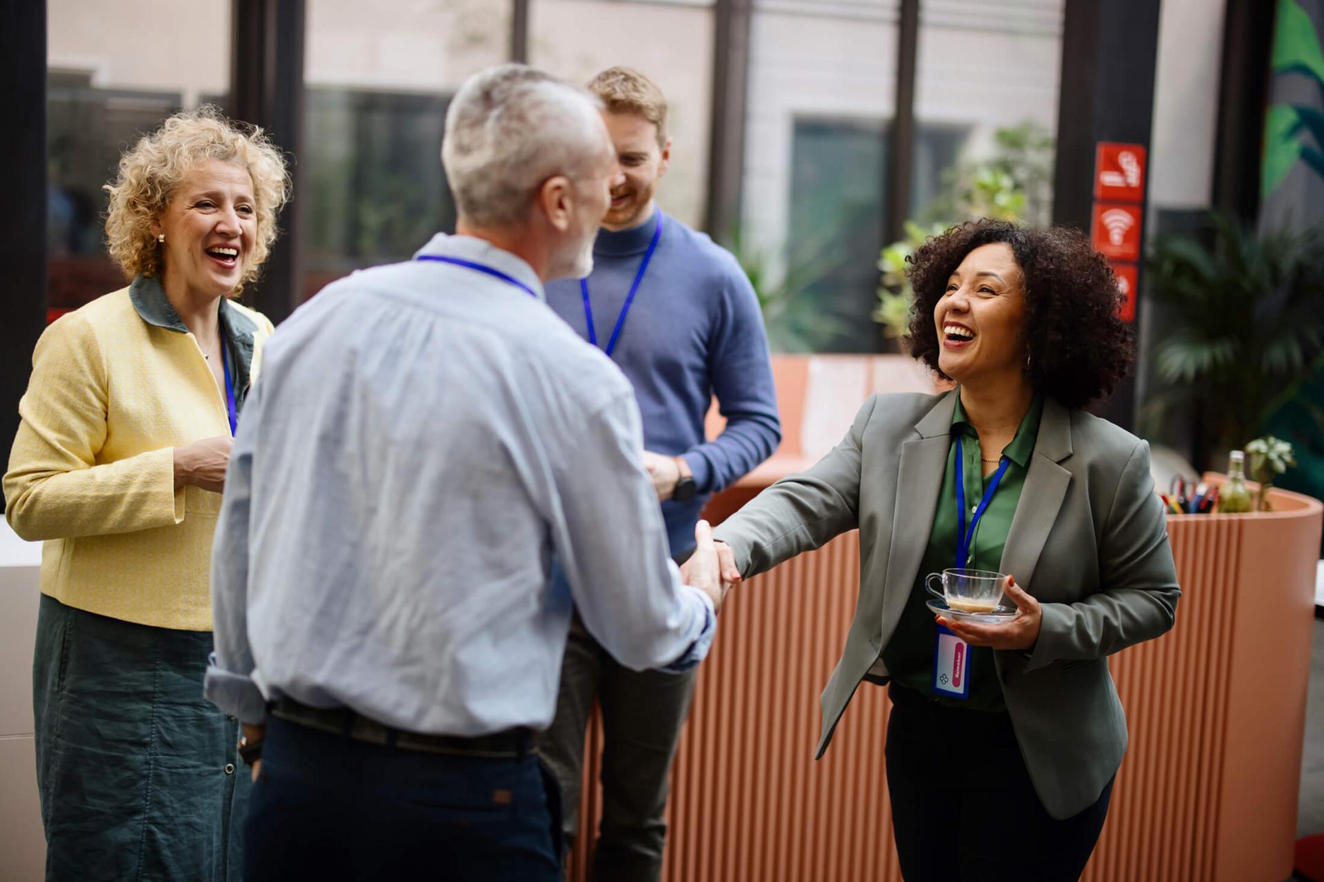 Two associates shake hands at a conference