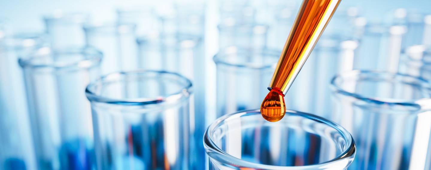 A medicine dropper dripping a tincture into a test tube