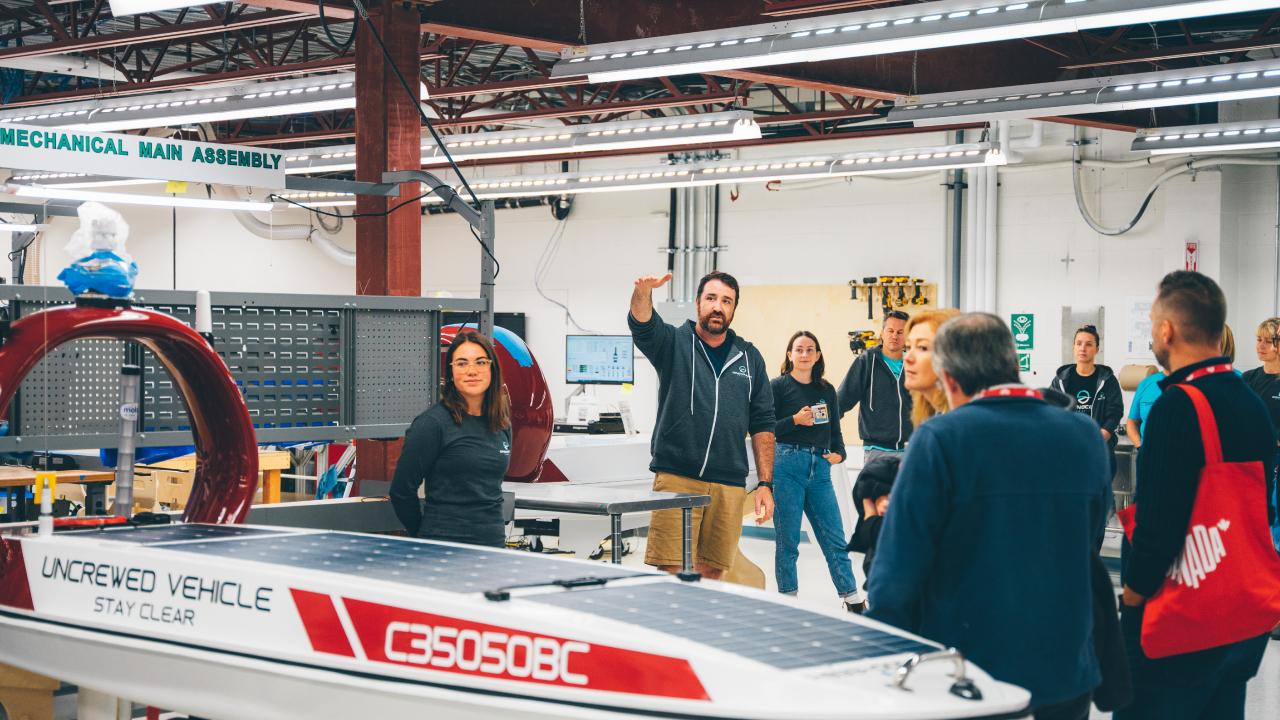 Expert présentant le véhicule de surface sans équipage à un groupe dans les installations